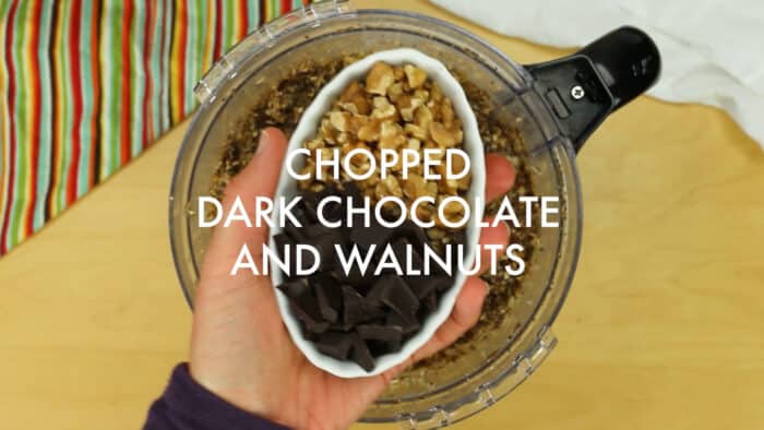 Adding chopped dark chocolate and walnuts to the food processor