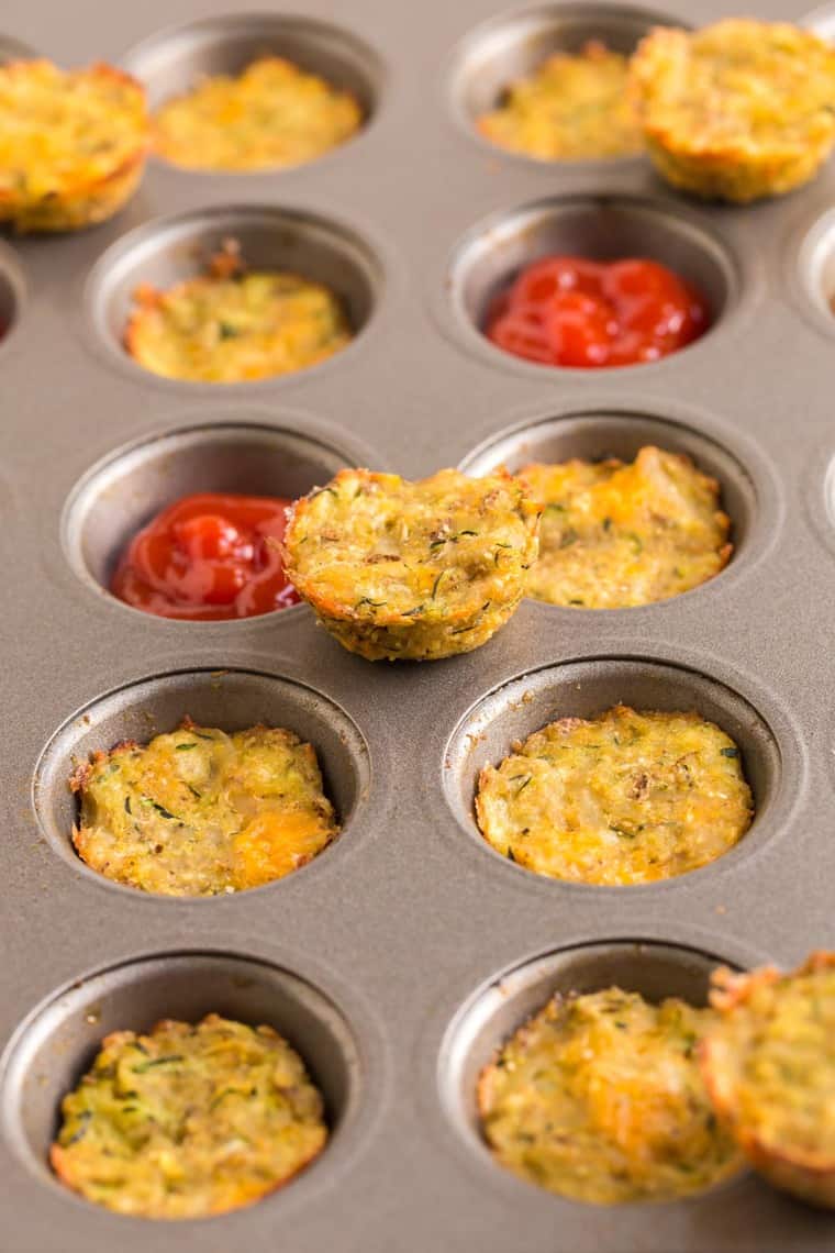Zucchini Tots in a mini muffin tin with two slots filled with ketchup
