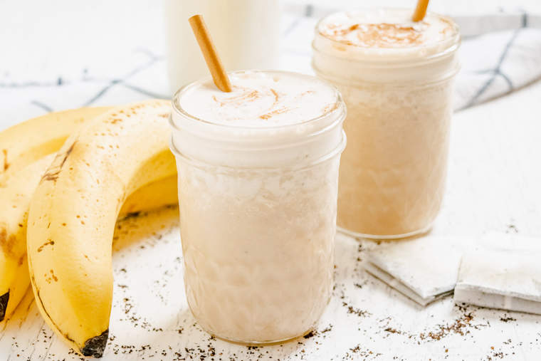 Chai Banana Smoothies in jars with bananas and chai tea bags in the background