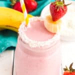 Overhead of a Coconut Strawberry Banana Smoothie garnished with coconut and fresh strawberries and bananas