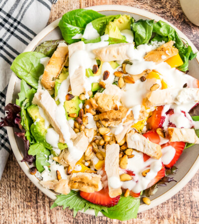 Overhead horizontal image of grilled chicken salad with strawberries and mango