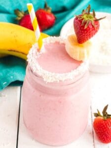 Overhead of a Coconut Strawberry Banana Smoothie garnished with coconut and fresh strawberries and bananas.