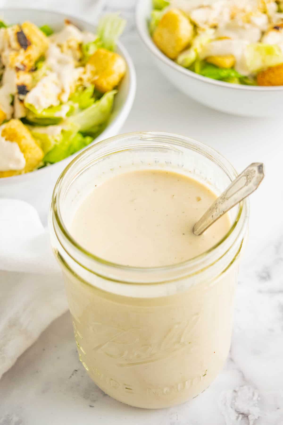A mason jar of Greek yogurt Caesar salad dressing.
