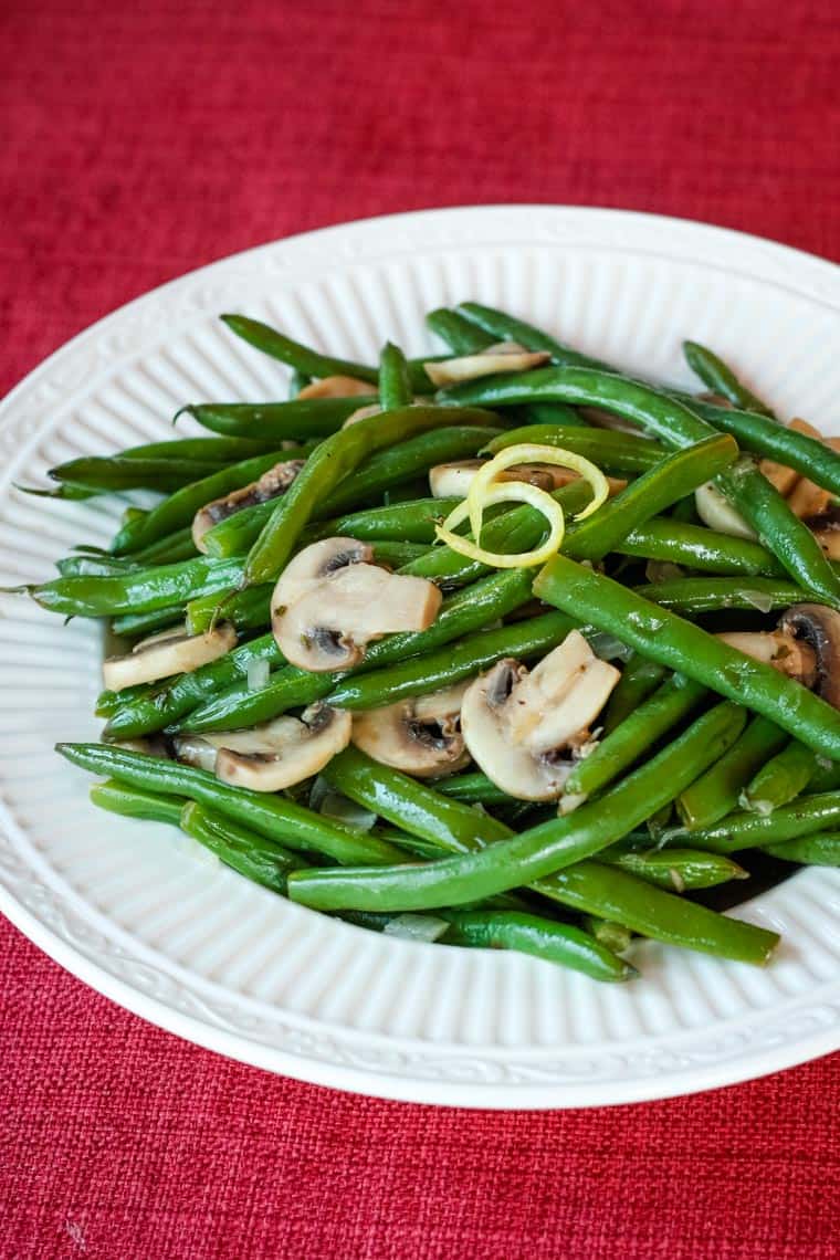 Lemon Butter Green Beans and Mushrooms served in a bowl on a red placemat