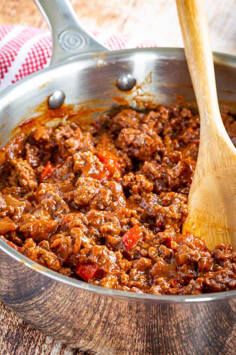Pan with ground beef sloppy joes meat and a wooden spoon