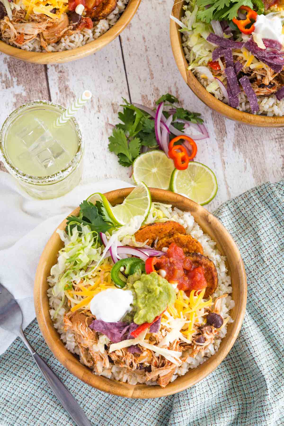 A Chicken Burrito Bowl made with cauliflower rice with a margarita next to it.