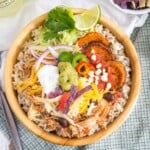 Chicken Burrito Bowl with toppings and garnished with lime and cilantro