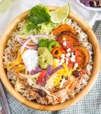Chicken Burrito Bowl with toppings and garnished with lime and cilantro
