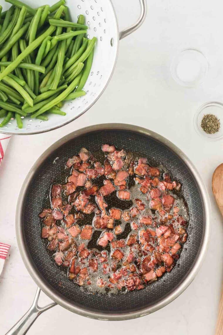 Cooked small pieces of bacon in a skillet with butter and oil.