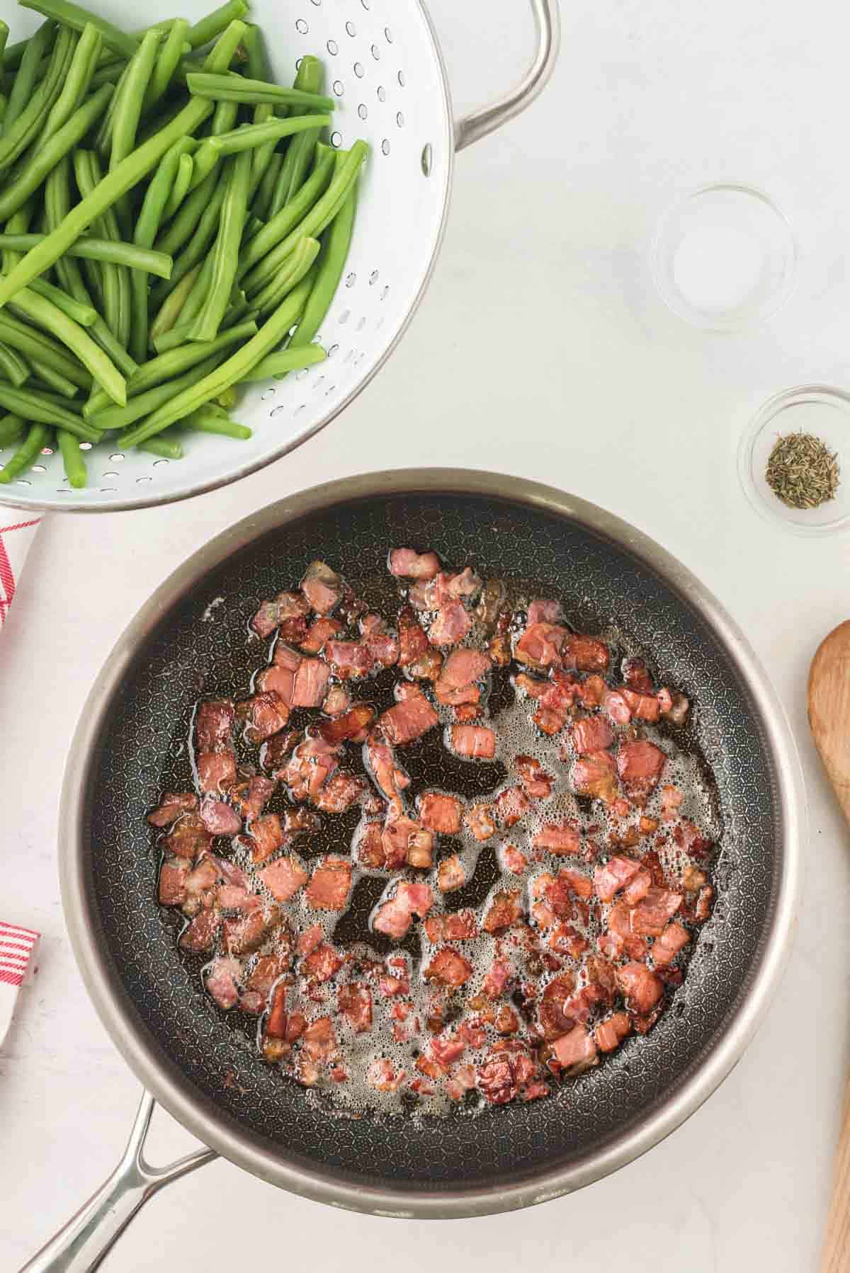 Cooked small pieces of bacon in a skillet with butter and oil.