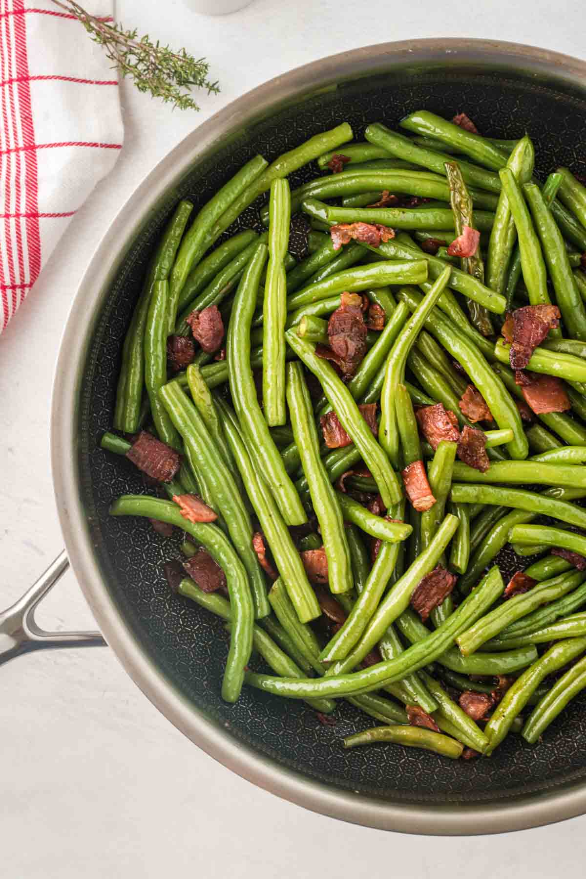 Looking down at sauteed Green Beans and Bacon in a Skillet.