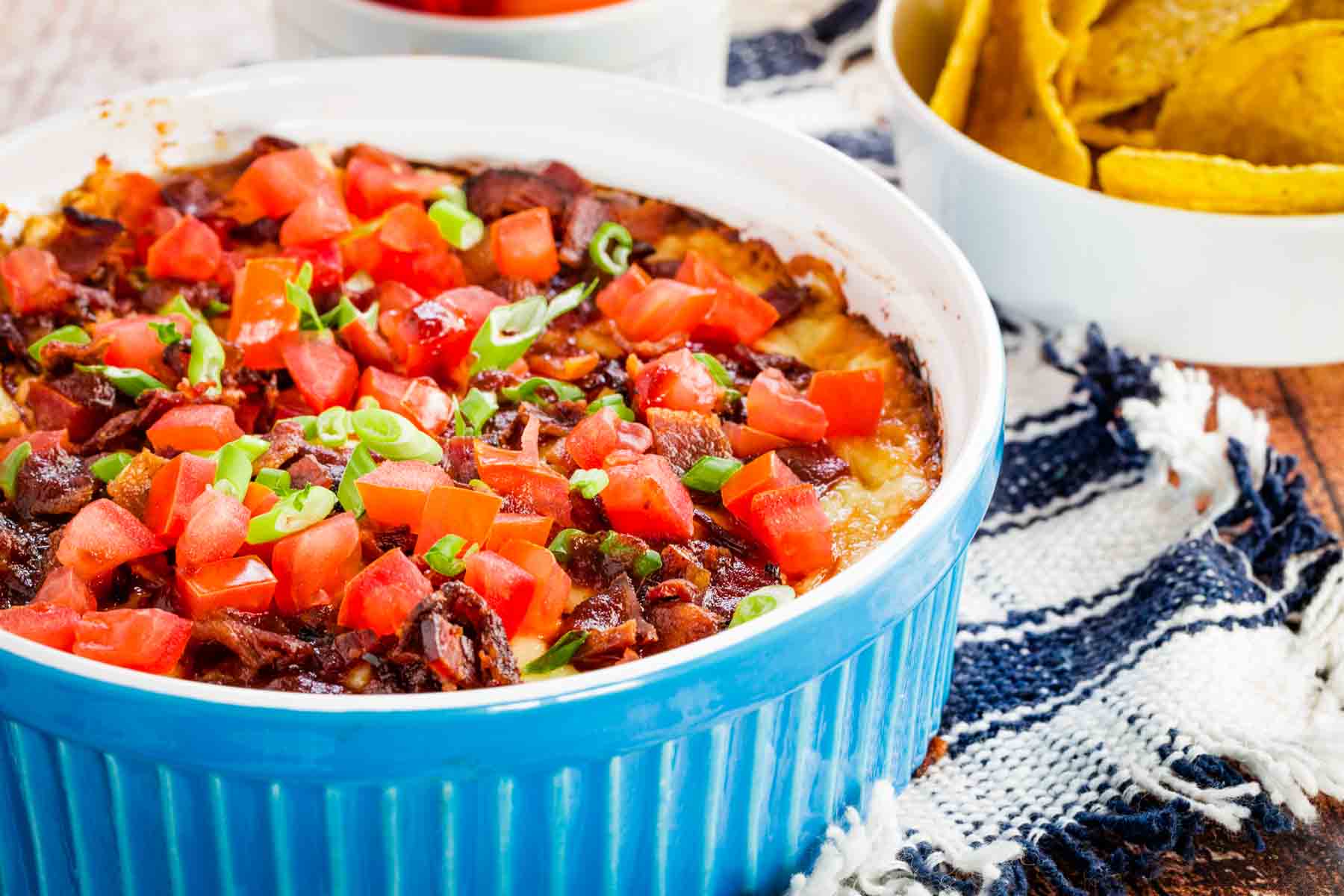 Hot dip in a casserole with a bowl of tortilla chips