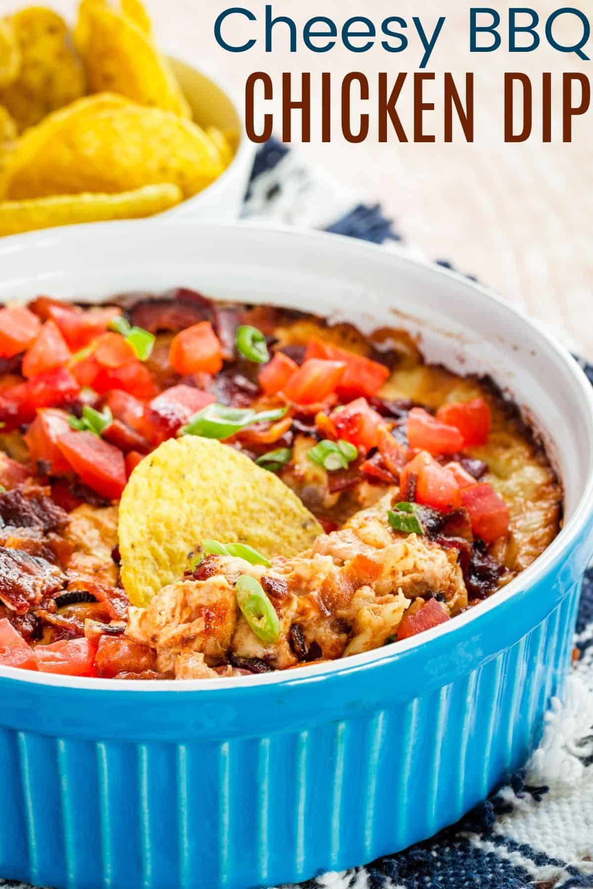 Blue casserole dish filled with Barbecue Chicken dip topped with bacon and tomatoes