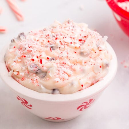 A small bowl of cheesecake dip with crushed candy canes on top