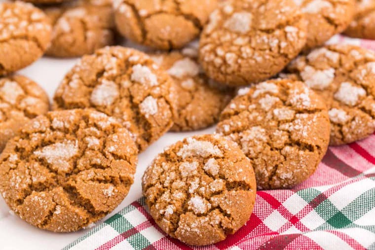 Scattered gluten free gingersnaps on a red and green plaid napkin