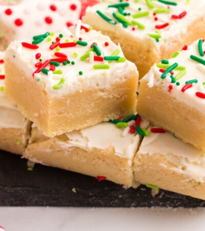 Gluten Free Sugar Cookie Bars with Christmas sprinkles on a slate platter