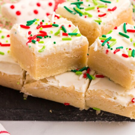 Gluten Free Sugar Cookie Bars with Christmas sprinkles on a slate platter
