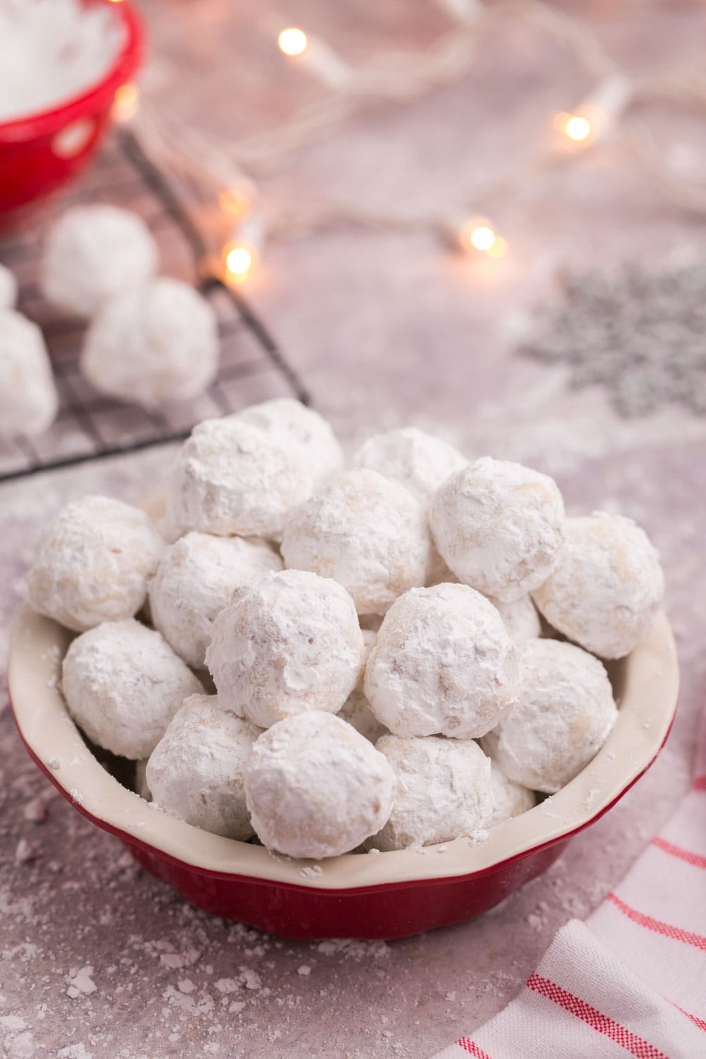 Red ball of snowball cookies with Christmas lights in the background