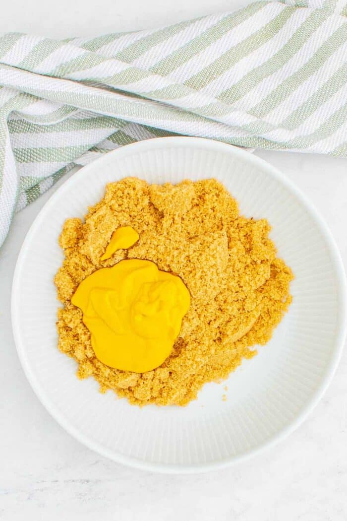 Brown sugar and yellow mustard in a white bowl