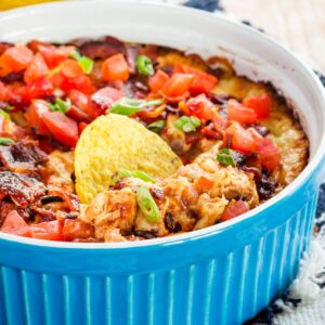 Tortilla chip stuch in a dish of hot Monterey Barbecue Chicken Dip