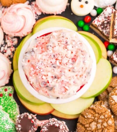 A platter of cookies with a bowl of peppermint chocolate chip cheesecake dip in the middle.