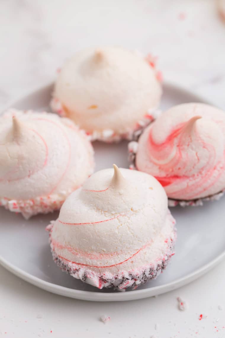 Four peppermint meringues on a white plare