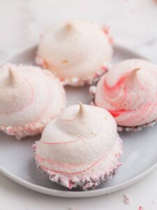 Four peppermint meringues on a white plare