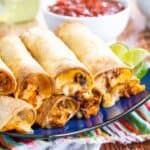 Air Fryer Chicken Taquitos in a stack on a blue plate