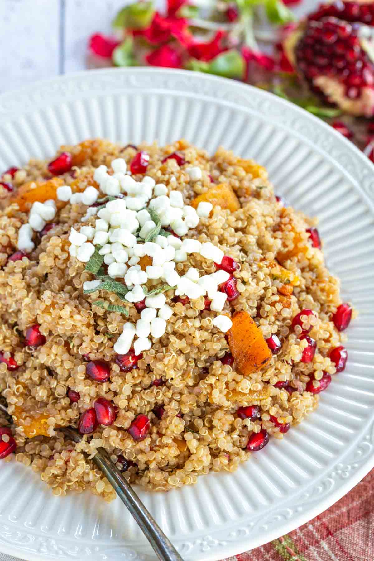 Butternut squash quinoa in a decorative serving bowl with a spoon in it