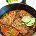 Overhead view of chili lime cube steaks in a cast iron skillet