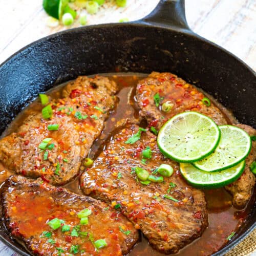 Overhead view of chili lime cube steaks in a cast iron skillet