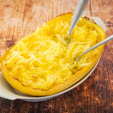 Spaghetti squash noodles in a halved squash with two forks