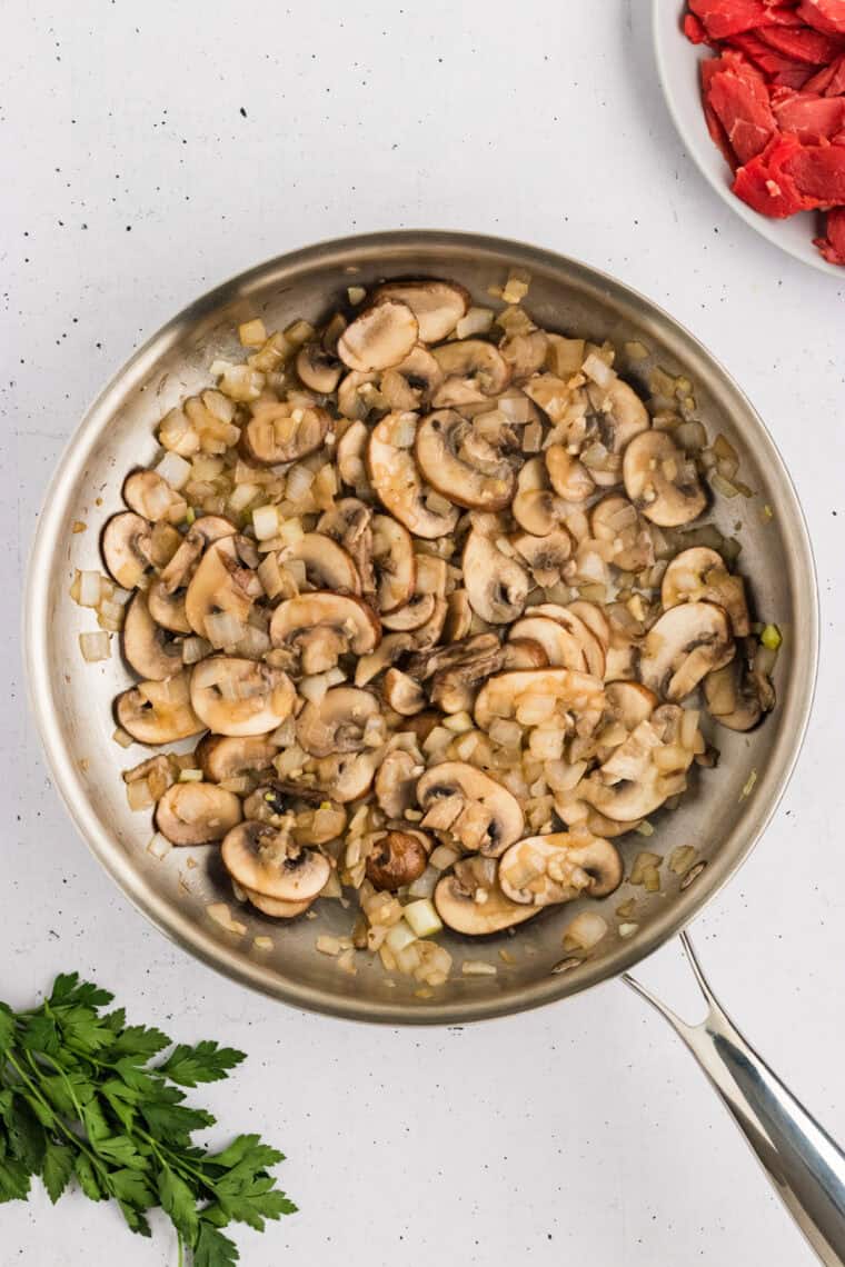 Cooked mushrooms and onions in a pan