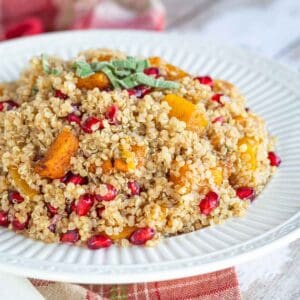 bowl of roasted butternut squash quinoa with pomegranate seeds mixed in