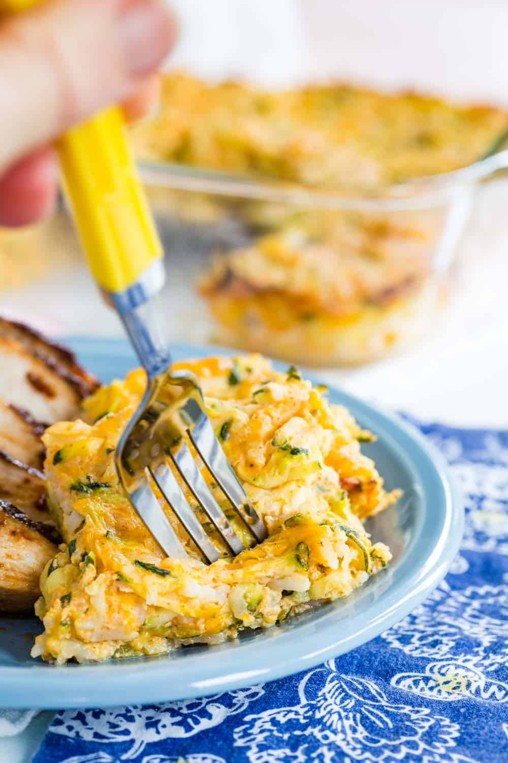 fork in a piece of Cheesy Zucchini Rice Casserole