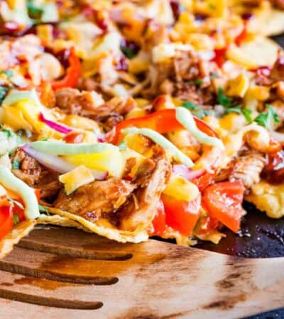 spatula picking up some of the nachos on a sheet pan