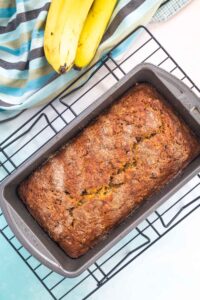 Banana bread in a pan on a cooling rack