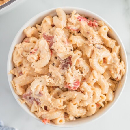 gluten free mac and cheese with bacon, chicken, and tomatoes served in a white bowl