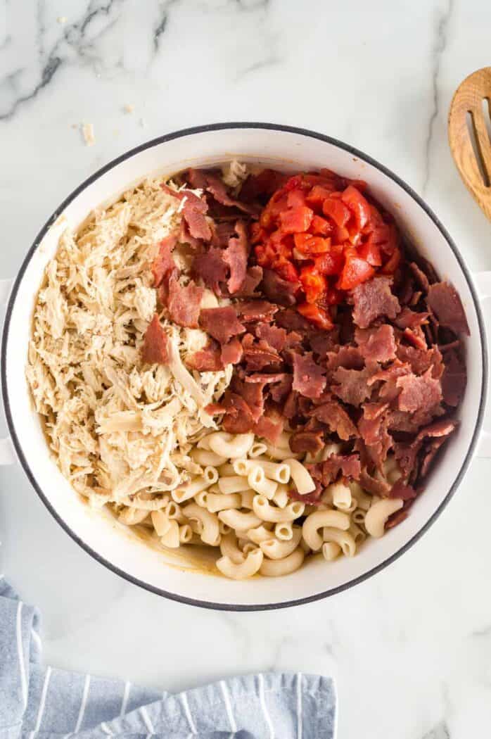 chicken, bacon, tomatoes, and elbow noodles added to the pot of cheese sauce