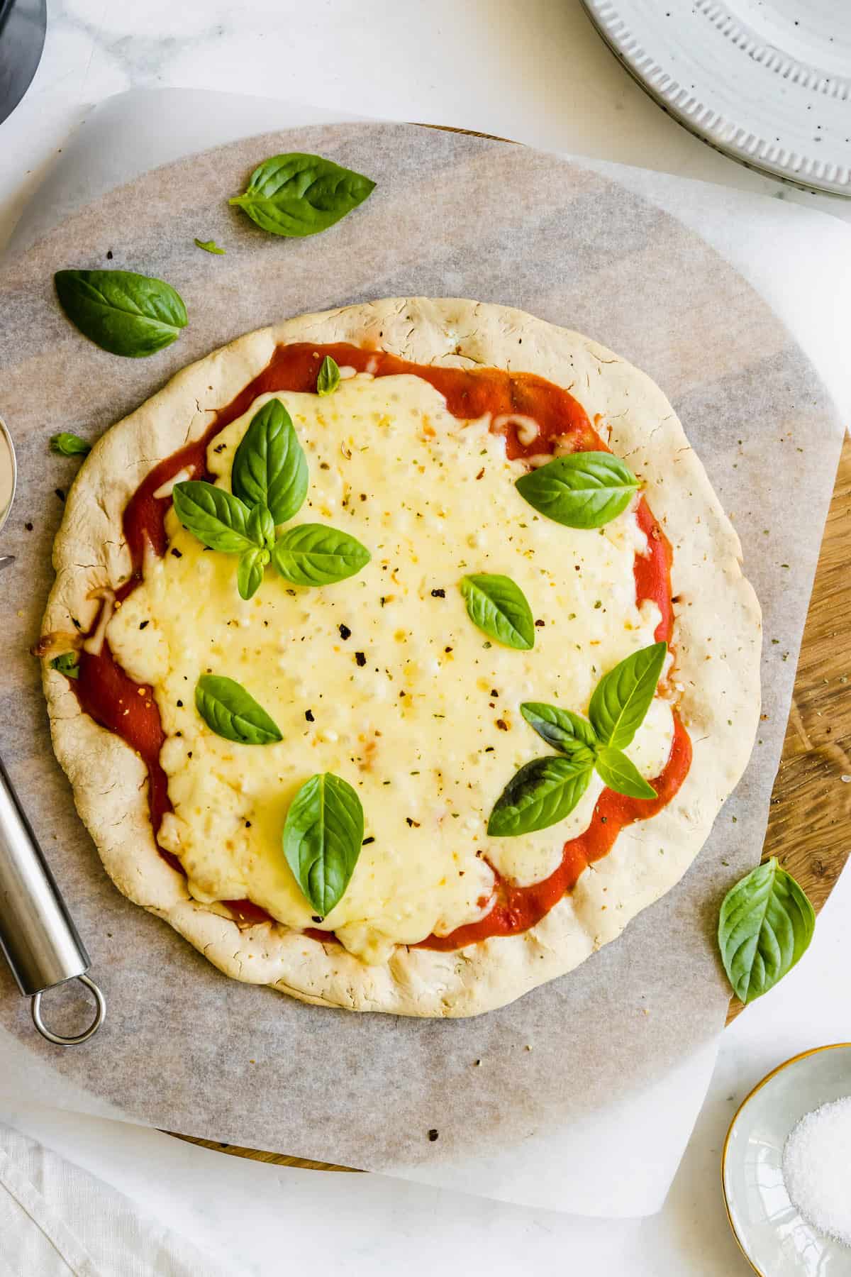 An Uncut Gluten-Free Pizza Sitting on a Wooden Pizza Stone