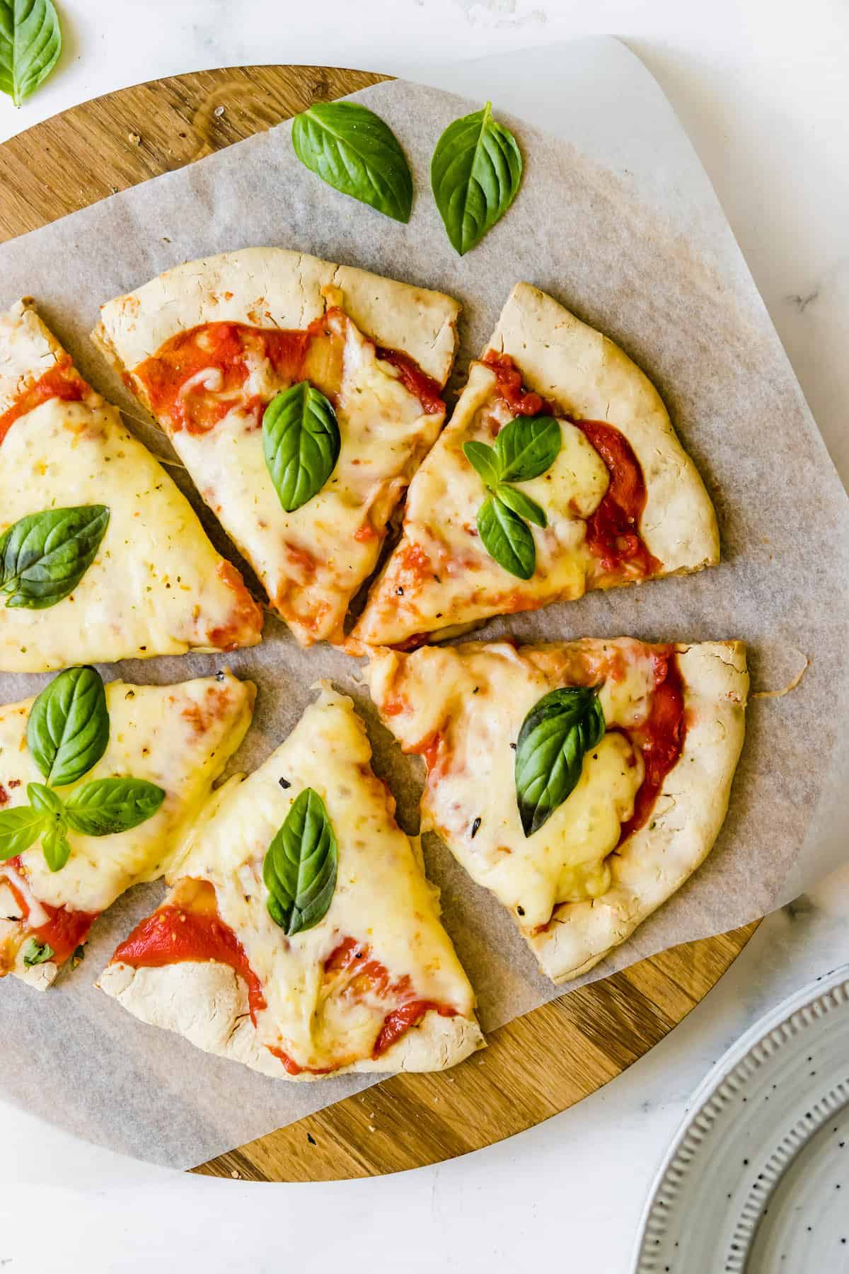 Six Slices of Gluten-Free Pizza on a Parchment-Lined Pizza Stone