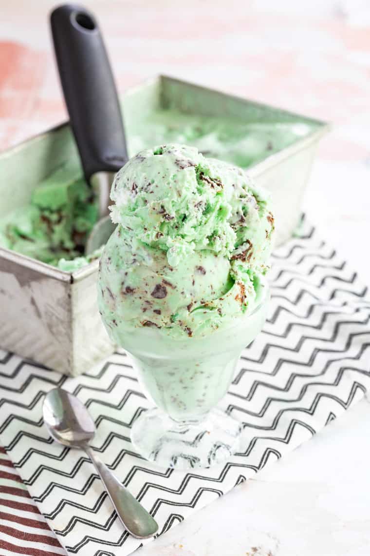 Scoopf of green ice cream filled with varying size pieces of chopped chocolate