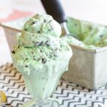 Mint ice cream with chocolate chunks and pieces that was scooped out of a loaf pan into a glass bowl