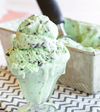 Mint ice cream with chocolate chunks and pieces that was scooped out of a loaf pan into a glass bowl