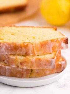 A stack of three slices of gluten free lemon pound cake on a white plate.