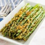 air fryer asparagus with parmesan cheese crust on a white rectangular plate