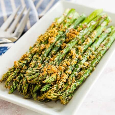 air fryer asparagus with parmesan cheese crust on a white rectangular plate