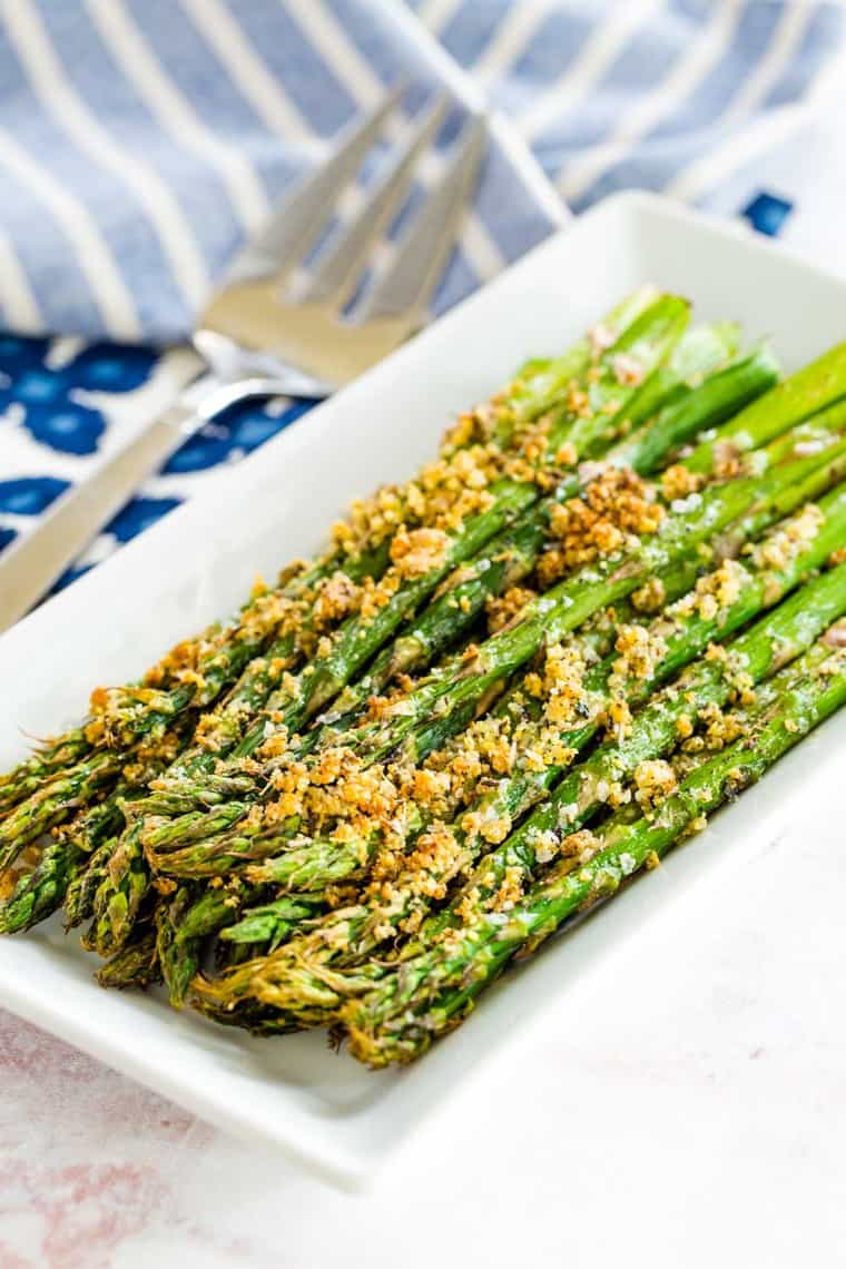 parmesan crusted air fryer roasted asparagus on a white rectangular plate