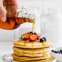 A Stack of Almond Flour Pancakes Topped with Berries and Maple Syrup