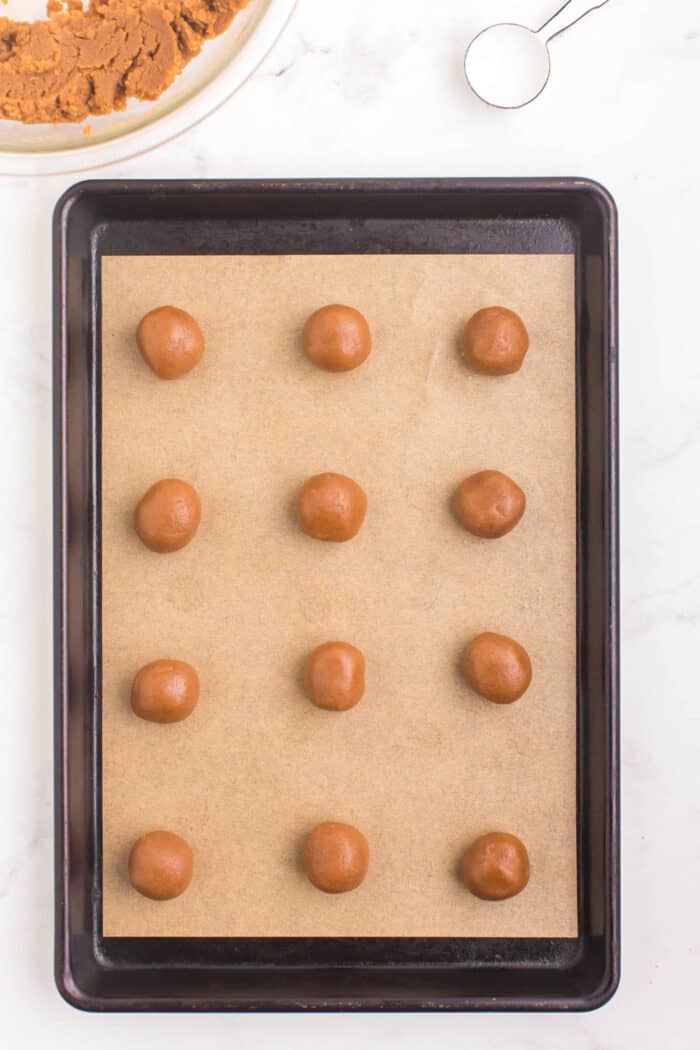 balls of cookie dough on a parchment-lined baking sheet